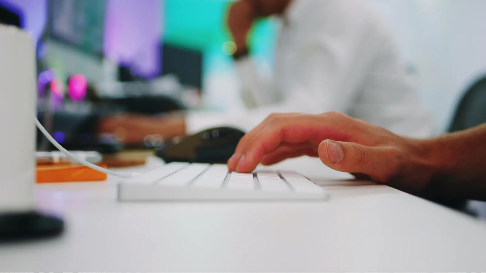 People typing in office desk